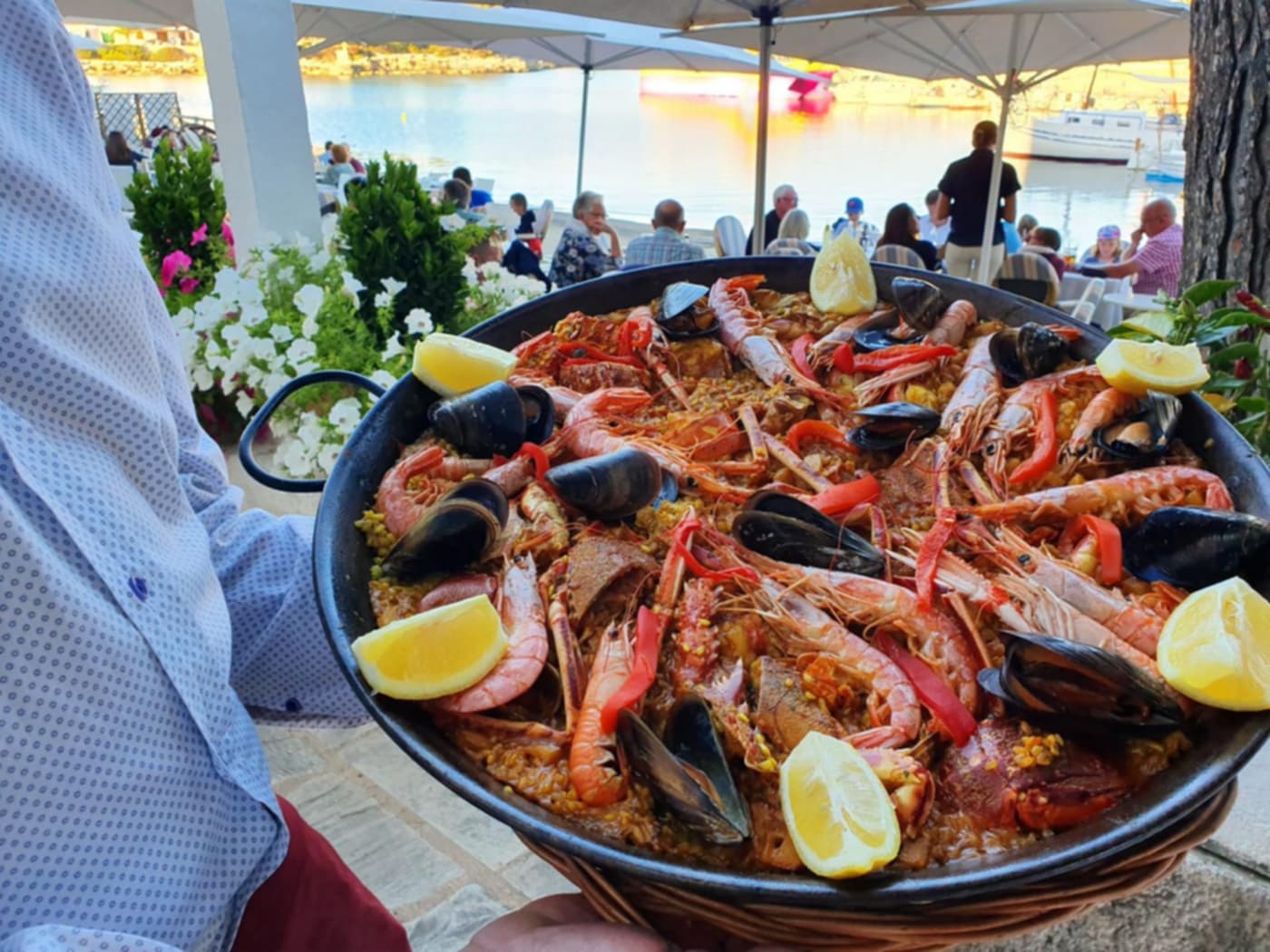 Paella de marisco servida en una mesa de la terraza de Ca’n Martina, en el puerto de Portopetro