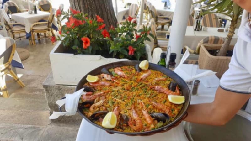 Paella recién servida sobre la mesa, en la terraza del restaurante